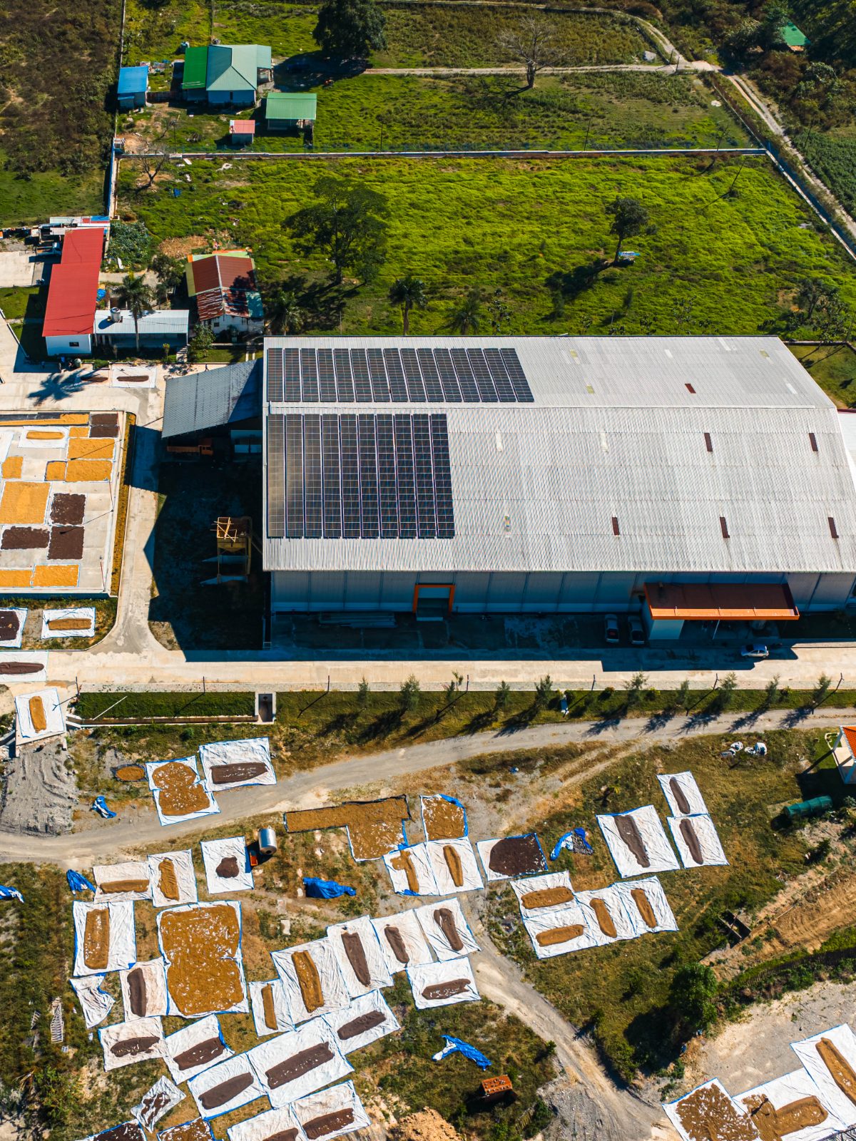 Aerial view of a processing facility with a rooftop solar array